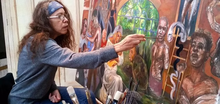 photograph of Stefanie Jackson painting on a canvas